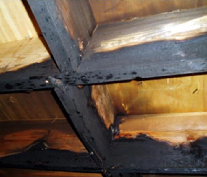 soot damage buildup on rafters after home fire